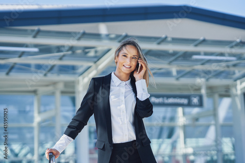 Adult female passenger using smartphone at the airport photo