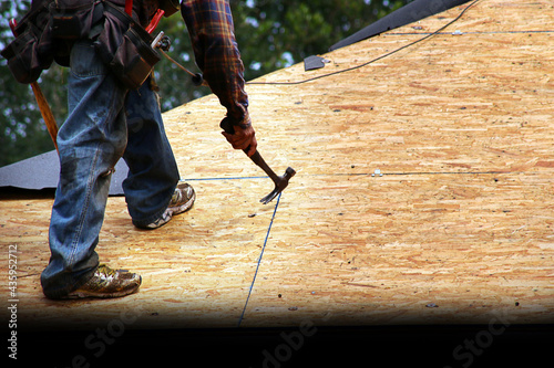 Roofer Removing Old Nails from Roof Deck