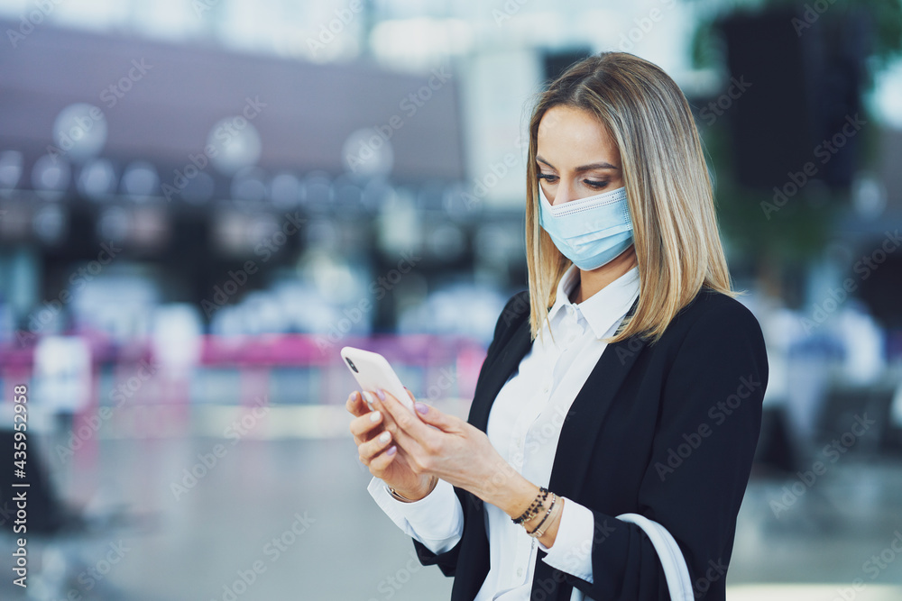 Adult female passenger using smartphone at the airport