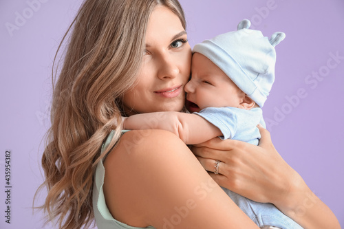 Happy mother with cute little baby on color background  closeup