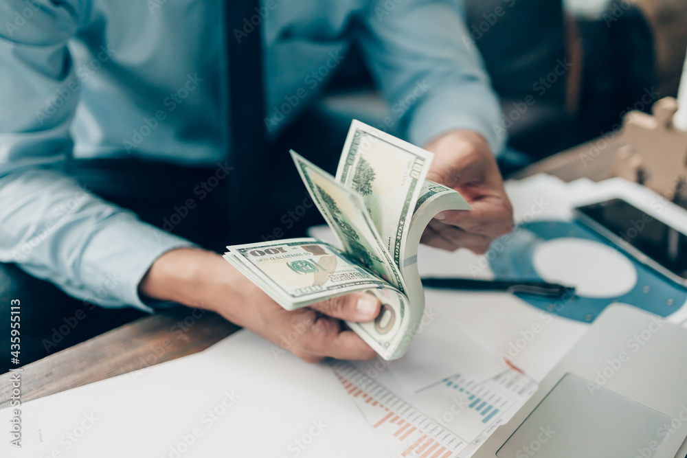 Fototapeta premium The rich businessman hands show the money American dollars Income and Business concept.