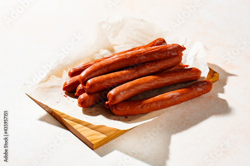 Fototapeta Naklejka Na Ścianę i Meble -  Smoked sausages with spices on a cutting board.