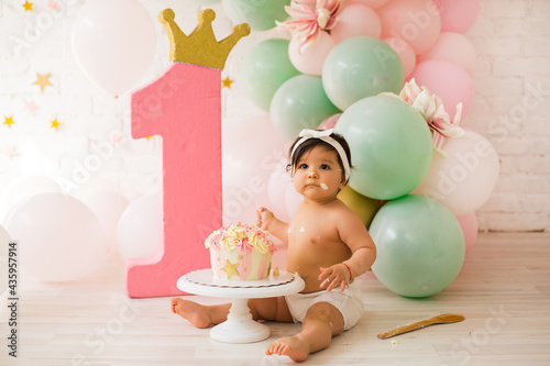 Baby girl  at first birthday with smash cake