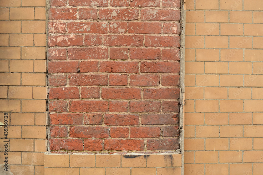 Collapsed cracked decorative imitation brick wall cladding on an old red brick wall Collapsed cracked decorative imitation brick wall cladding on an old red brick wall