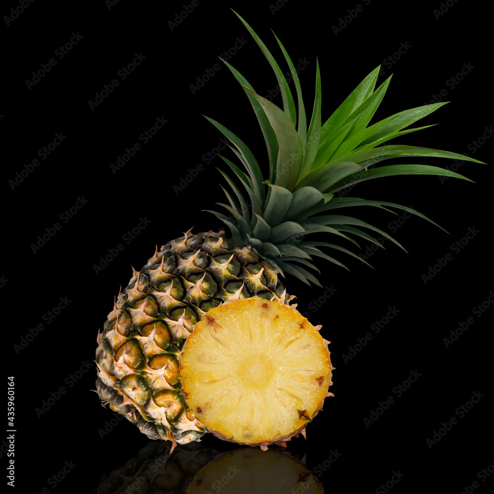Whole pineapple and cut in half isolated on black background. Picture of tropical fruit Whole pineapple and cut in half isolated on black background. Picture of tropical fruit