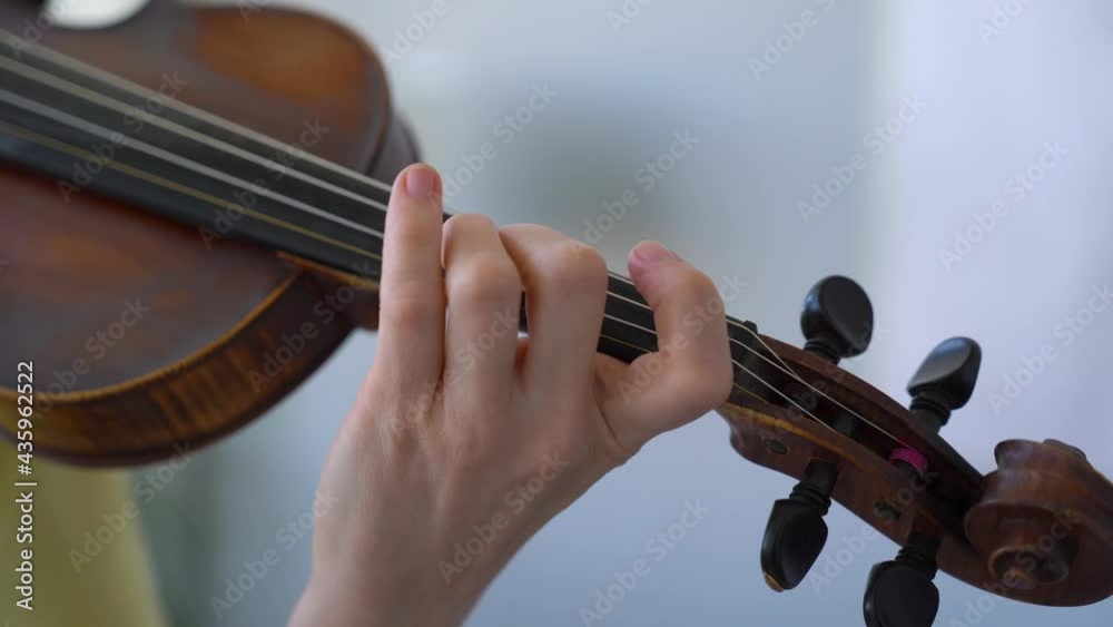 Close-up of female hand Learning Different Vibrato Techniques. Playing the violin. Close-up of female hand Learning Different Vibrato Techniques. Playing the violin.