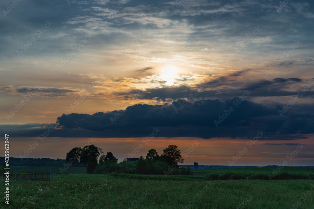 The evening,morning cloud sun and field among trees In the warm summer weather,Nice colored evening summer landscape. The evening,morning cloud sun and field among trees In the warm summer weather,Nice colored evening summer landscape.