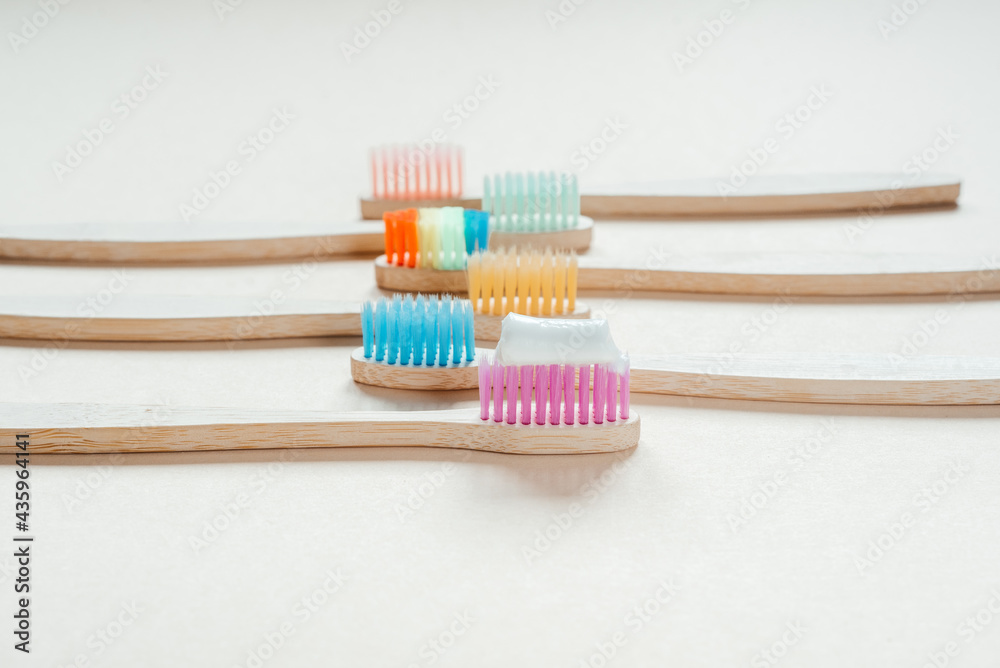 Colorful eco friendly bamboo toothbrushes on light pastel background, dental care with zero waste concept, sustainable lifestyle Colorful eco friendly bamboo toothbrushes on light pastel background, dental care with zero waste concept, sustainable lifestyle