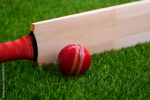 Canvas Print cricket bat and ball placed on cricket ground green grass