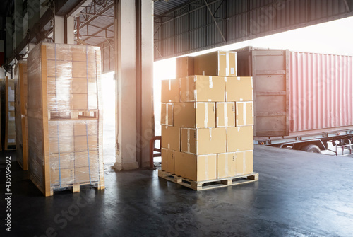 Stacked of Package Boxes Load into Cargo Container. Truck Parked Loading at Dock Warehouse. Delivery Service. Shipping Warehouse Logistics. Shipment Freight Truck Transportation.	
