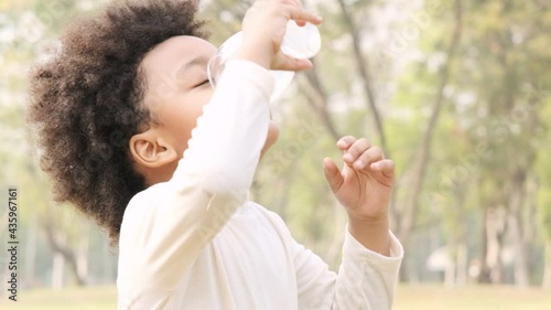 Cute black child was drinking milk from the glass and was deliciously licked around his mouth,slow motion shot.