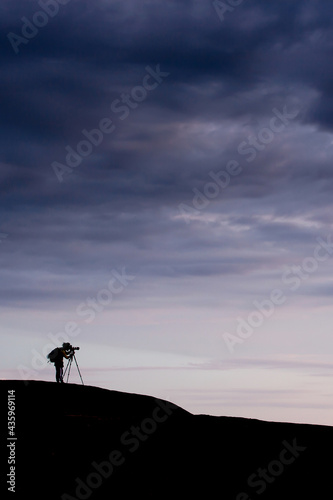 Young man taking pictures on the mountain peak.