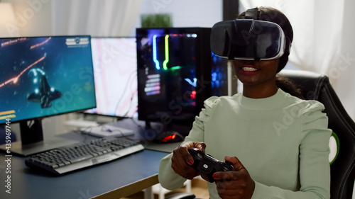 Focused african cyber player wearing virtual reality headset during online championship holding controller. Game over for pro gamer using wireless joystick for space shooter gaming competition