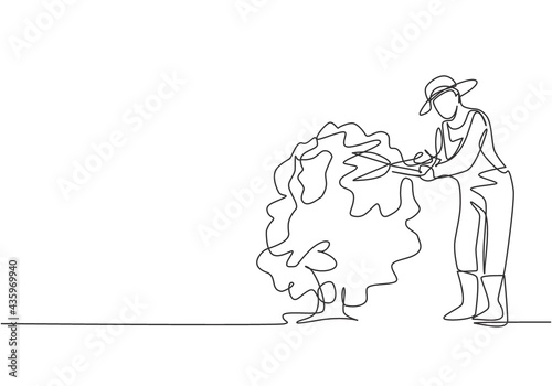 Single one line drawing of young male farmer cut the leaves on the tree using plant scissors. Farming challenge minimalist concept. Modern continuous line draw design graphic vector illustration.