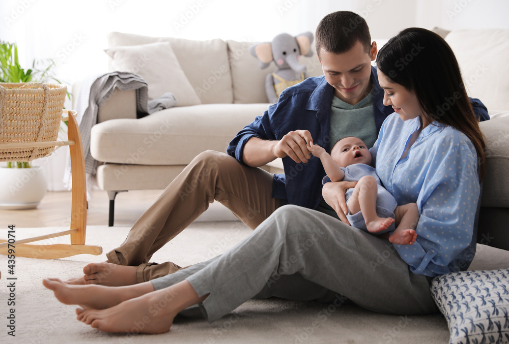 Happy family with cute baby near sofa at home Happy family with cute baby near sofa at home