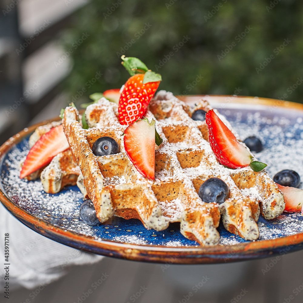 Obraz premium Traditional Belgian dessert - waffle with strawberry and cream.