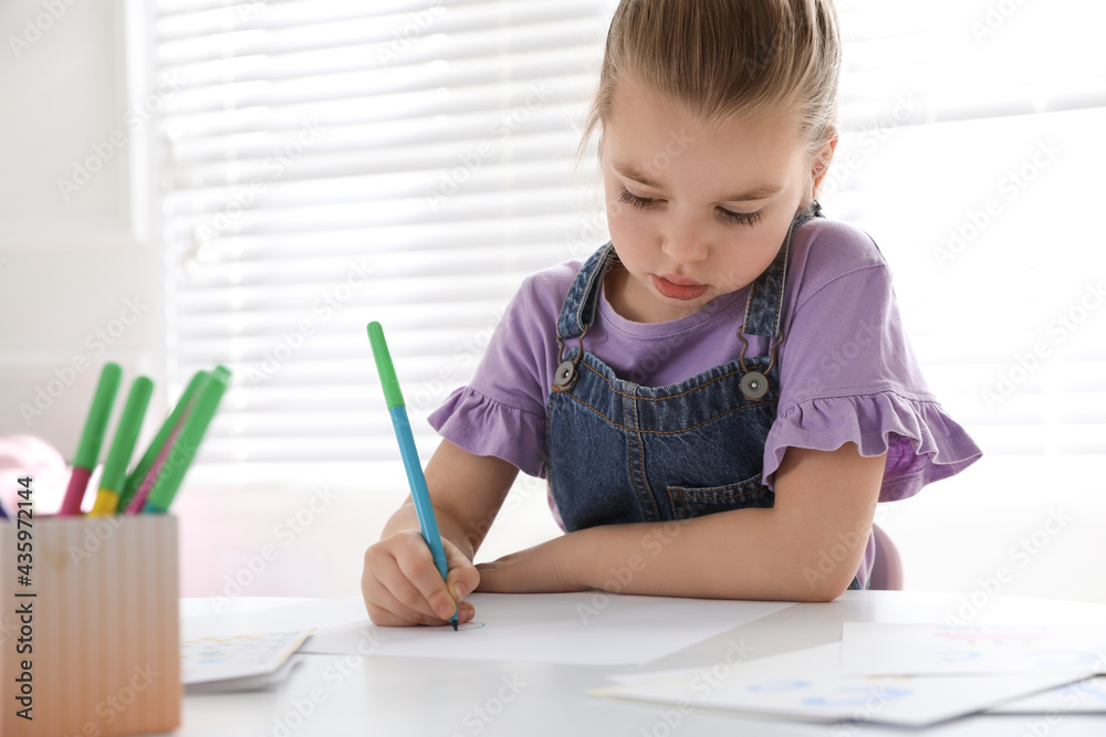 Little girl writing in classroom at English lesson Little girl writing in classroom at English lesson