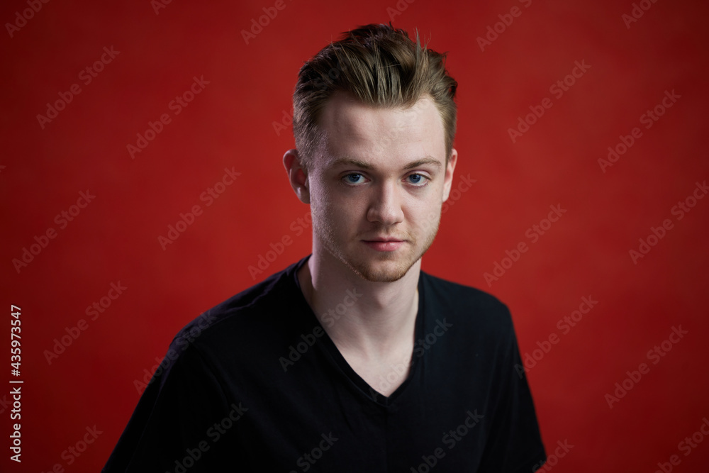 High resolution photo portrait of cute caucasian guy in studio on red background High resolution photo portrait of cute caucasian guy in studio on red background