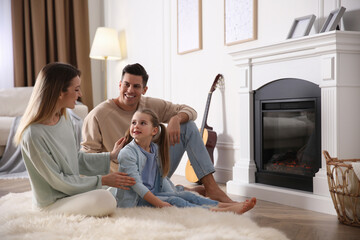 Happy family resting near fireplace at home