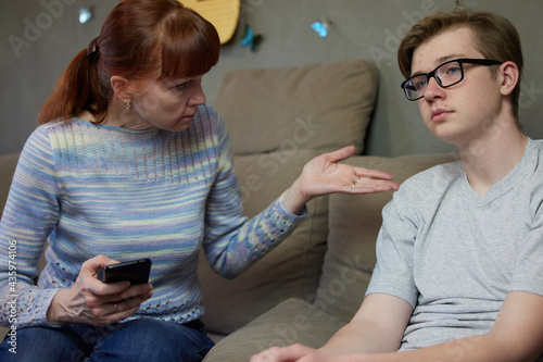 High resolution photo mother talking next to indifferent son at home