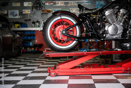 Obraz na plátne motorcycle raised on the platform to be repaired in a mechanic's shop