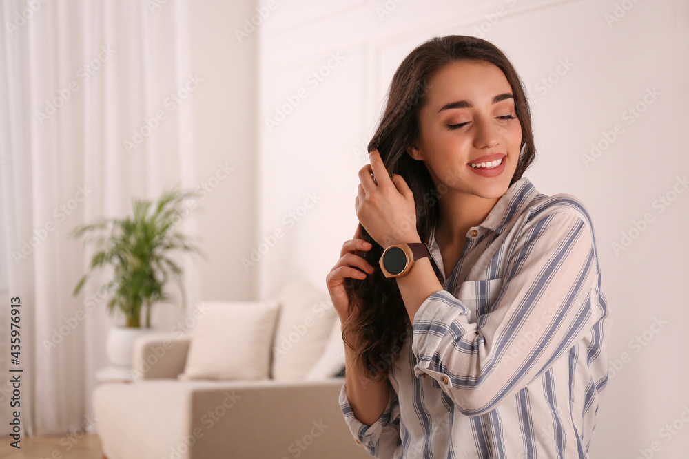 Young woman with smart watch at home, space for text Young woman with smart watch at home, space for text