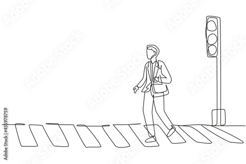 Continuous one line drawing a male worker crosses the road on the zebra crossing after returning from work. There's a traffic light there too. Single line draw design vector graphic illustration.