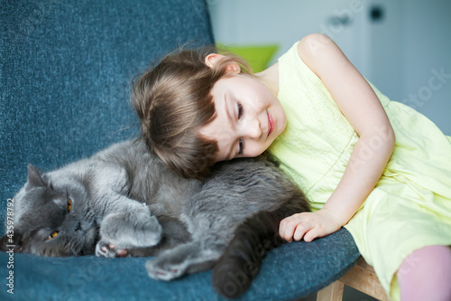 little girl cuddling to her cat
