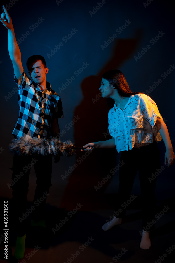 Fototapeta premium A guy in a plaid shirt and a girl with a dust brush against a dark background