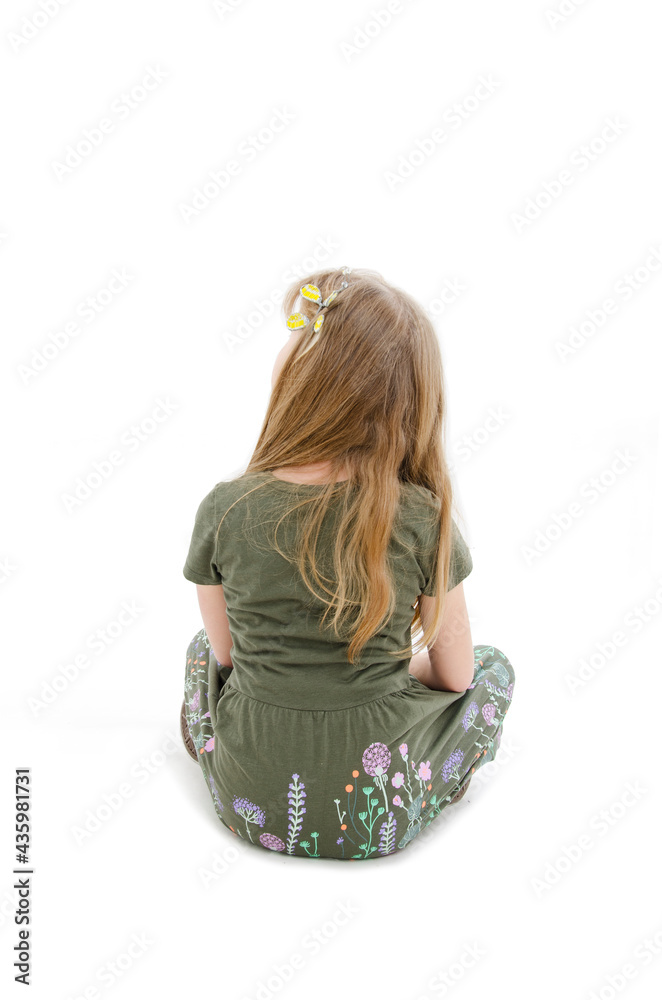 Rear view of little girl sitting on floor looking up. Isolated on white ...