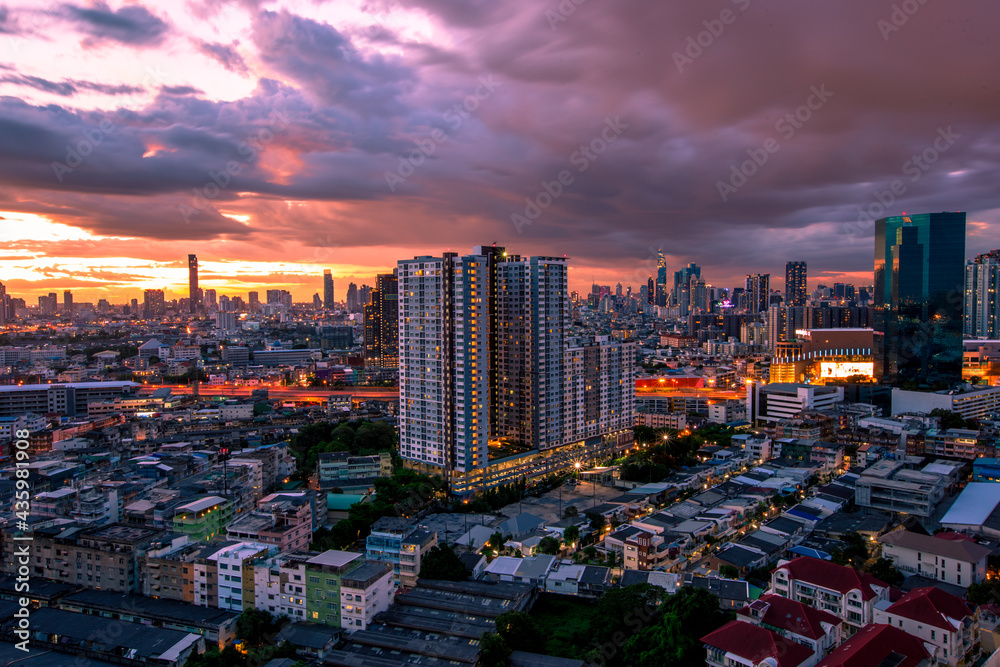 Obraz premium The high angle background of the city view with the secret light of the evening, blurring of night lights, showing the distribution of condominiums, dense homes in the capital community