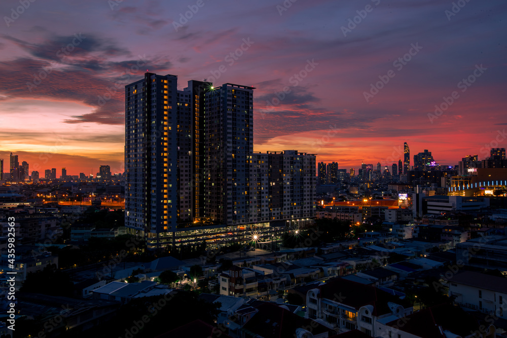 Obraz premium The high angle background of the city view with the secret light of the evening, blurring of night lights, showing the distribution of condominiums, dense homes in the capital community