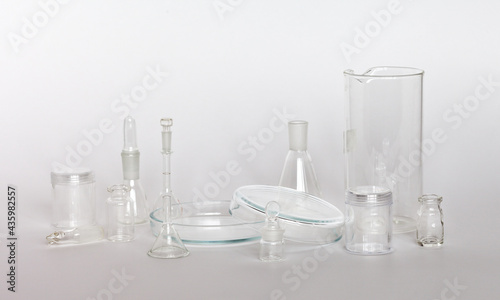 A set of glass chemical glassware on light laboratory table. Science, education and research concept. Composition from laboratory glassware. High key. Chemical background. Focus on the petri dish