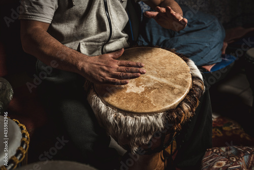 Hands of a drummer playing the ethnic percussion musical instrument djembe