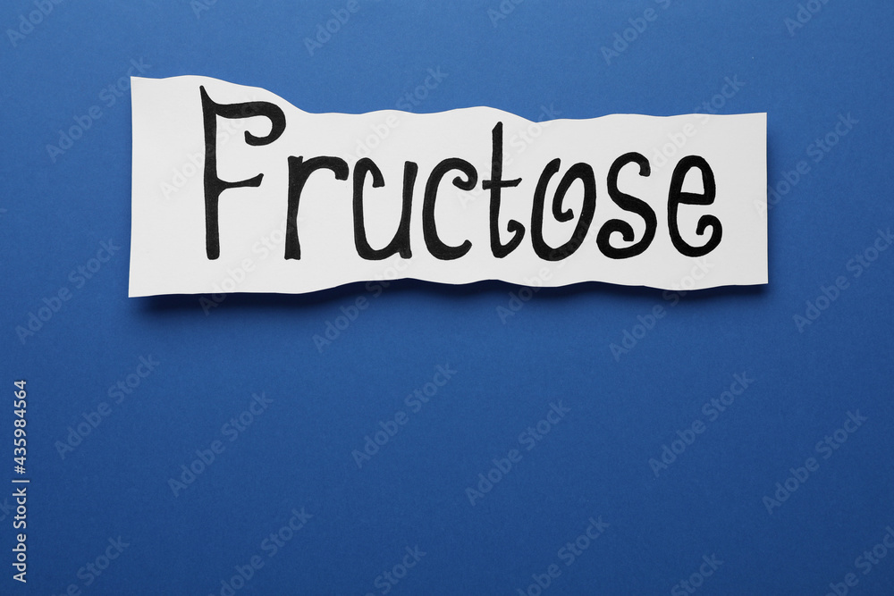 Paper sheet with word Fructose on blue background, top view. Space for text Paper sheet with word Fructose on blue background, top view. Space for text
