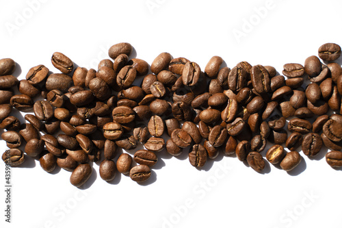 Isolated roasted coffee beans in harsh light
