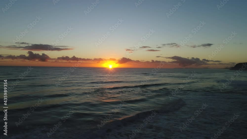 Aerial view of a beautiful sunrise over a calm ocean with the sun reflecting off the waves at Miami Gold last Australia. Aerial view of a beautiful sunrise over a calm ocean with the sun reflecting off the waves at Miami Gold last Australia.