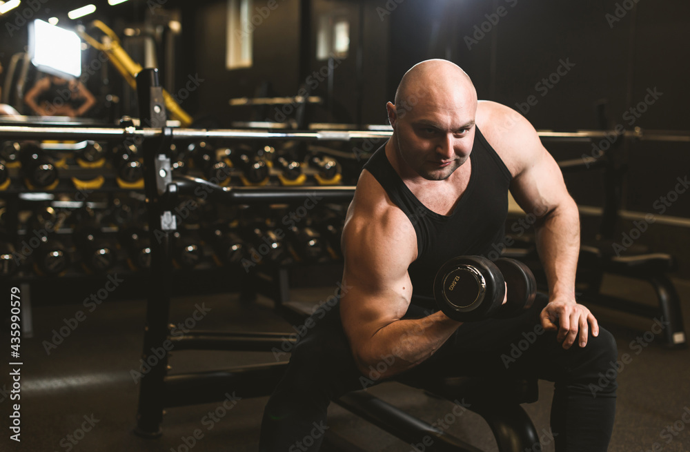 Muscular man working out in gym doing exercises with dumbbells at biceps, strong male naked torso abs. Fitness crossfit bodybuilding concept Muscular man working out in gym doing exercises with dumbbells at biceps, strong male naked torso abs. Fitness crossfit bodybuilding concept