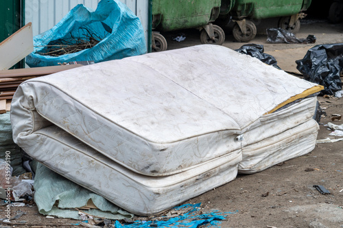 old mattress thrown in the trash