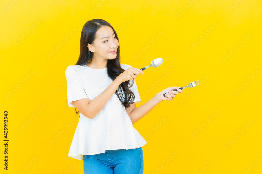 Portrait beautiful young asian woman smile with spoon and fork Portrait beautiful young asian woman smile with spoon and fork