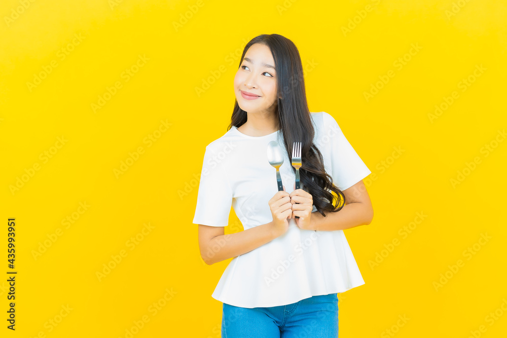 Portrait beautiful young asian woman smile with spoon and fork Portrait beautiful young asian woman smile with spoon and fork