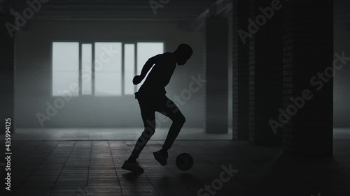 Wallpaper Mural African-american soccer player practicing kicks and moves inside empty covered parking garage. Slow motion black man work out soccer dribbling in underground parkin in sunlight. Torontodigital.ca