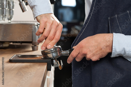 Barista pressing fresh coffee grounds in a cafe  selective focus