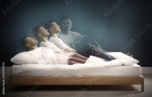 Somnambulist rising from bed near dark wall indoors, multiple exposure. Sleepwalking photo