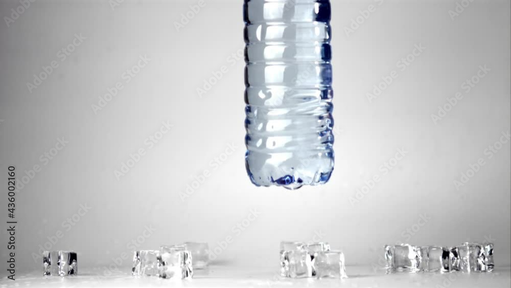Super slow motion on the table falls a bottle of water. Filmed at 1000 fps.On a white background. 