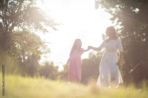 Mother and daughter together in nature. Walking and holding hands.