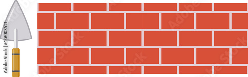 Brick wall and trowel. Brown brick. Brick masonry.