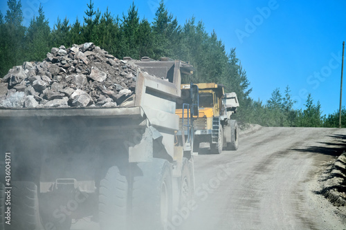 Bild auf Leinwand A big dump truck is moving along the highway