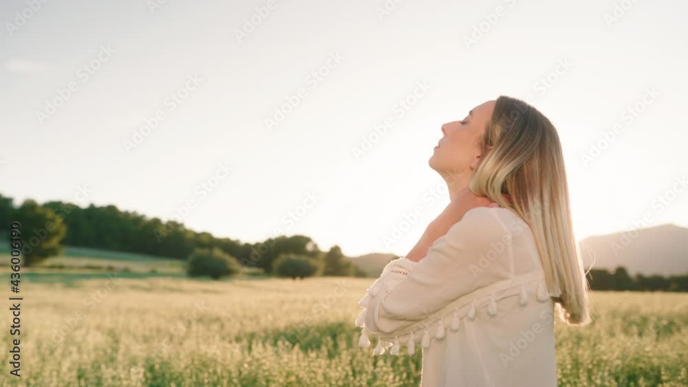 Woman standing on farm field and looking up to the sky during sunset,close up Woman standing on farm field and looking up to the sky during sunset,close up