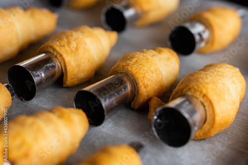 Lots of sweet home made confectionery tubes prepared to be filled with cream. Photo taken under soft artificial light.